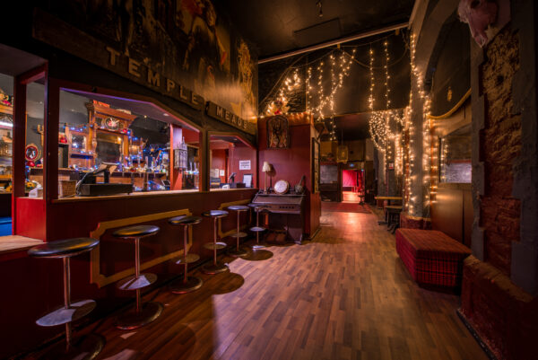 a bar and seating area lit by yellow fairy lights.