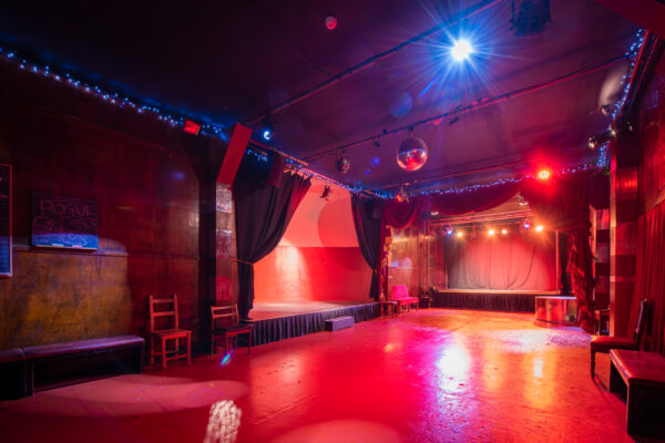 a red dance floor and stage lit by red and white lights