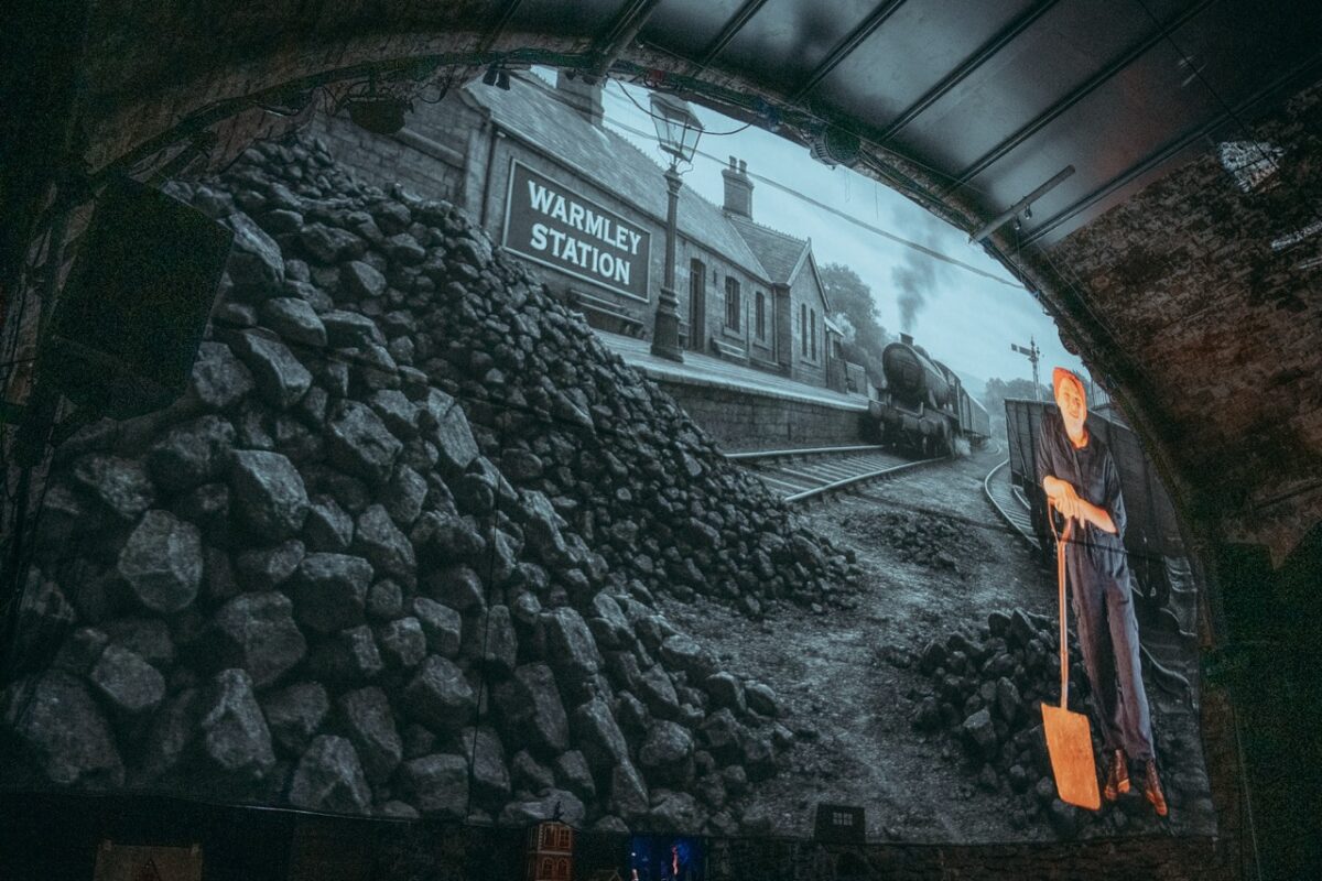 a projection of a blacka and white photo of a train station on the wall of one of the loco klub tunnels. 