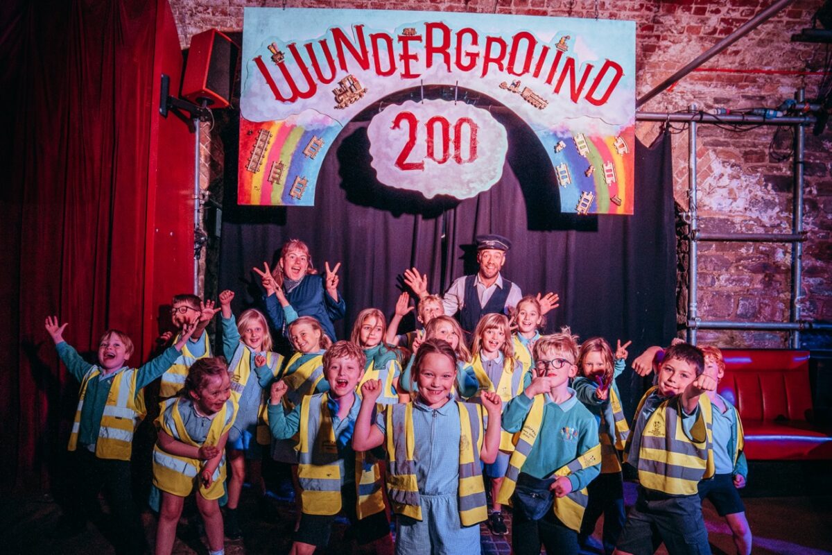 children posing in front of the Wunderground 200 sign. 