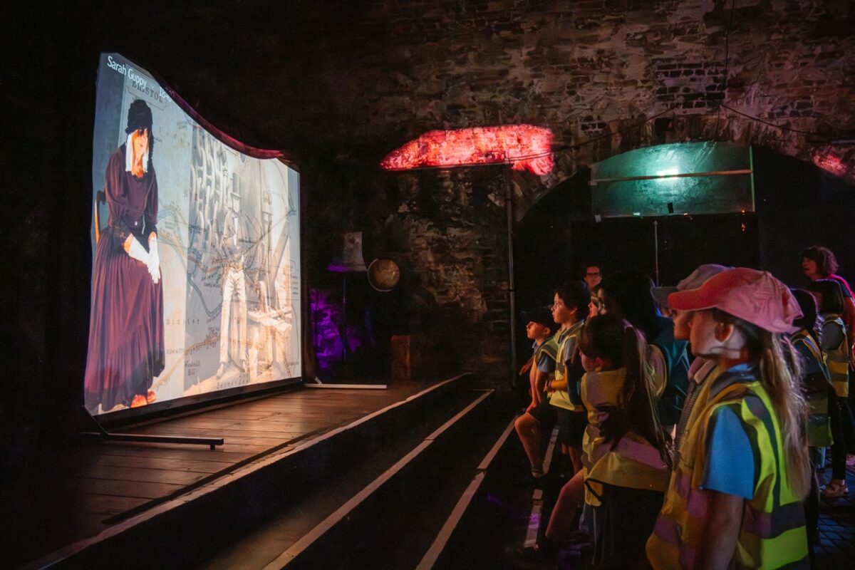 a projection ebing showed to a crowd of children and adults in one of the tunnels at loco klub. 